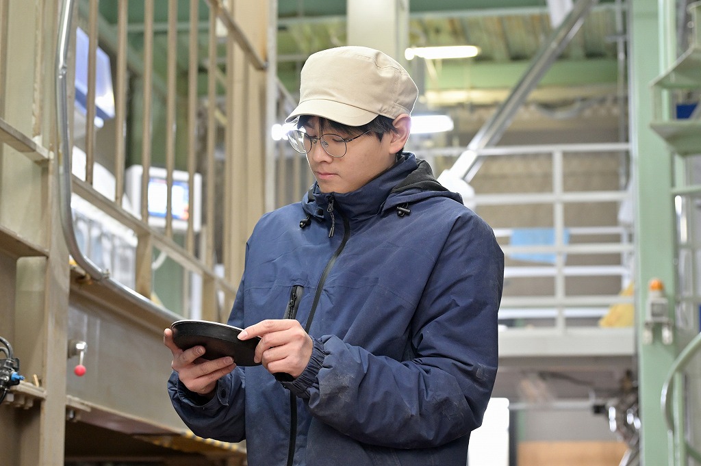 工場でタブレットを使い確認する福井精米のスタッフ